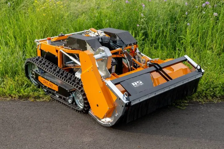 Mähraupe mit Schlegelmuclher AS motor Ovis RC präsentiert sich halb auf dem weg und halb in der Wiese.